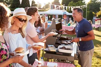 volunteer serving bbq at community fete