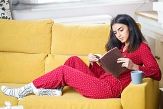 in pjs cosy and reading a book