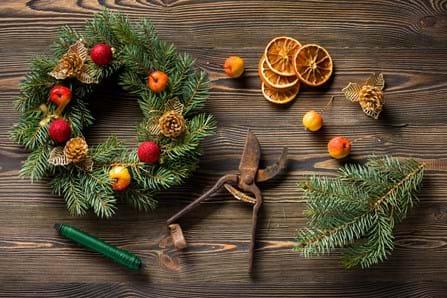 Natural Christmas wreath on brown wooden table top view